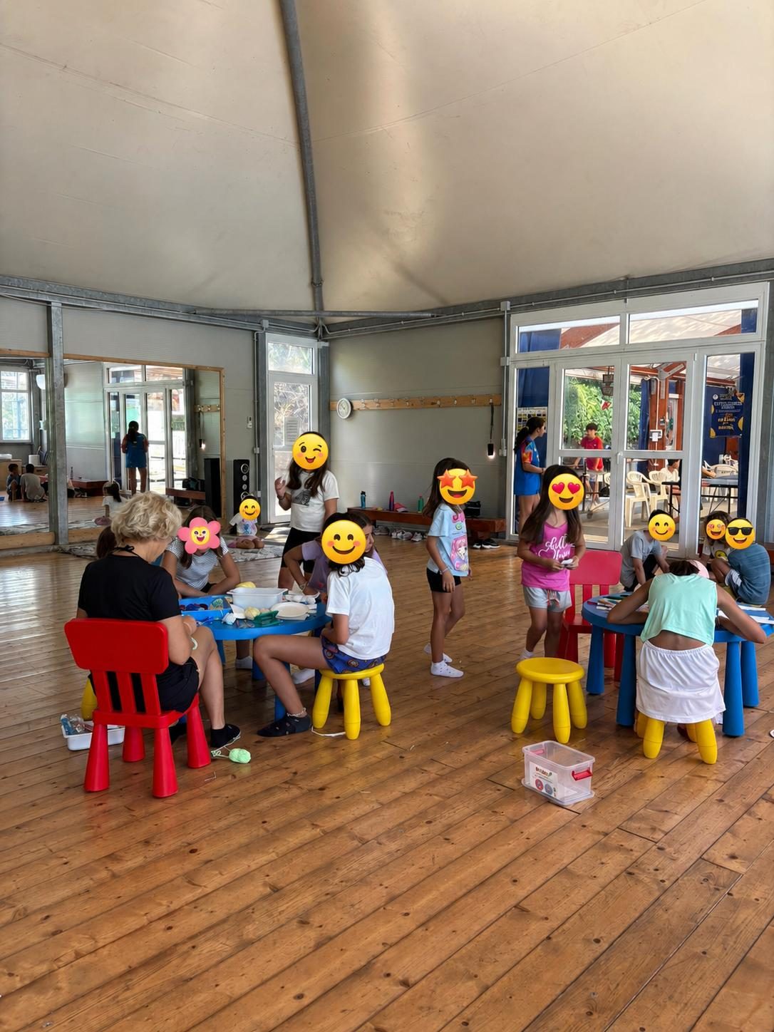 Bambini del centro estivo impegnati in un laboratorio ai tavoli