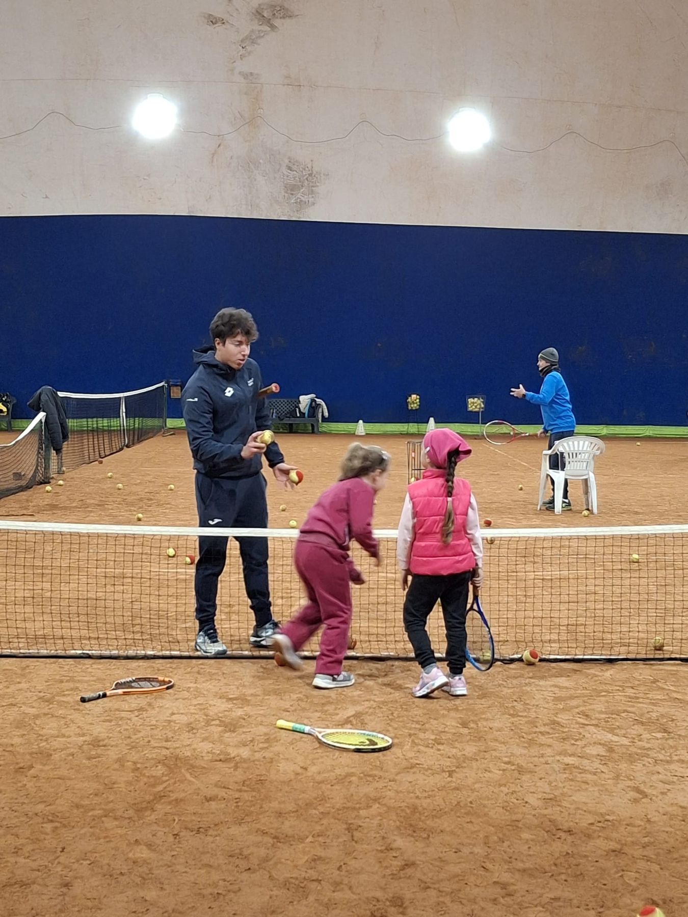 Lezione della scuola tennis con i bambini in campo